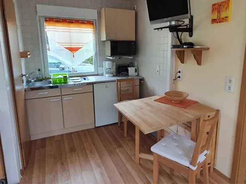 Bungalow 155 am Zeulenrodaer Meer – Küche mit Kochfeld und Kühlschrank